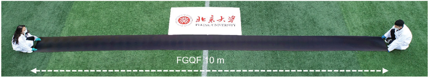 Researchers displaying a long sheet of graphene glass-fiber material